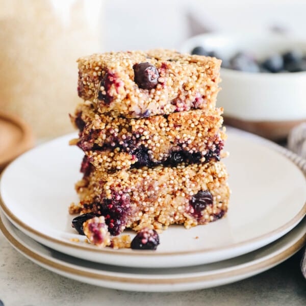 blueberry quinoa bars stacked in three on a white plate.