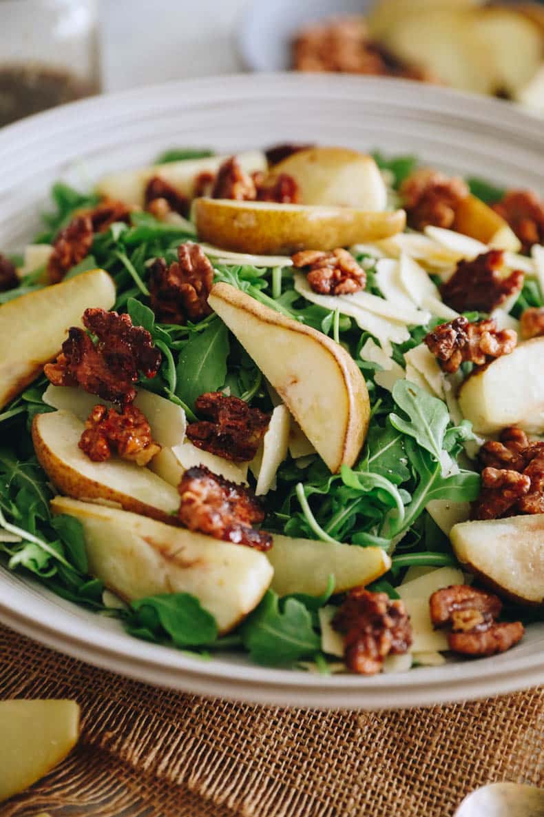 close-up image of pear salad with arugula, parmesan and candied walnuts