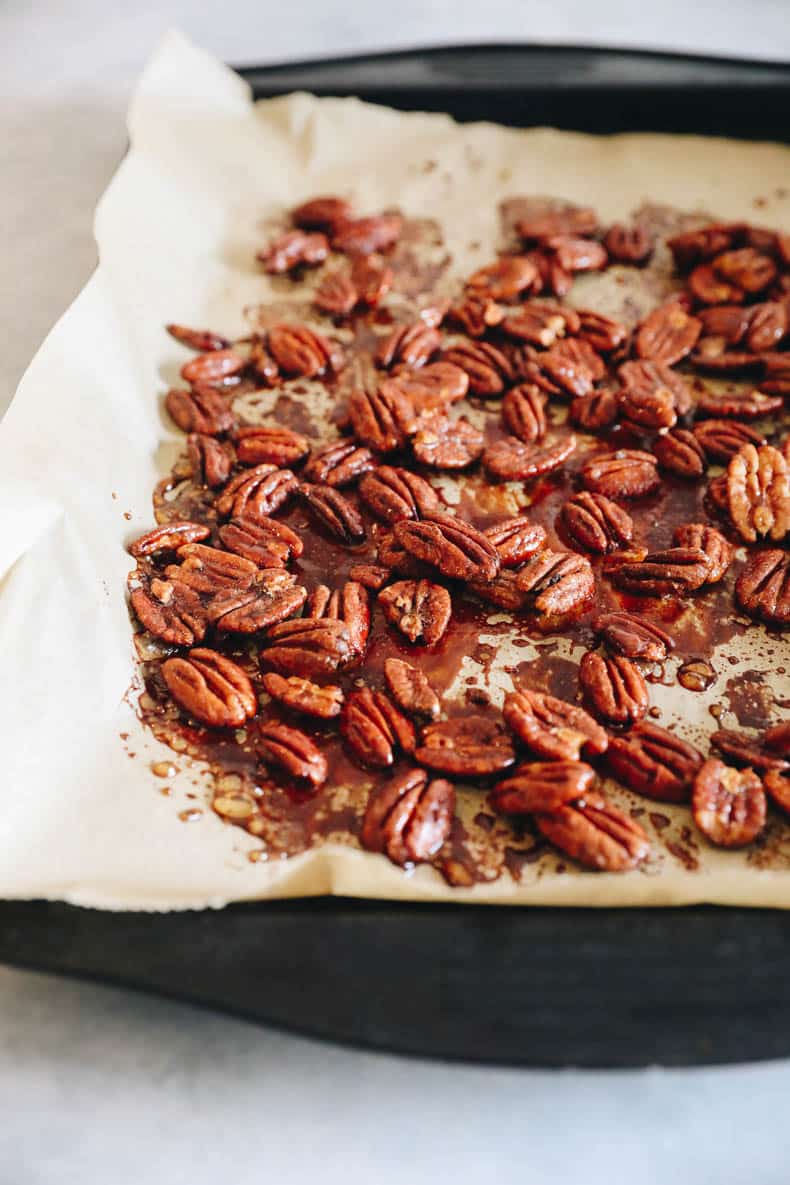 Sweet and spicy roasted pecans on a baking sheet.